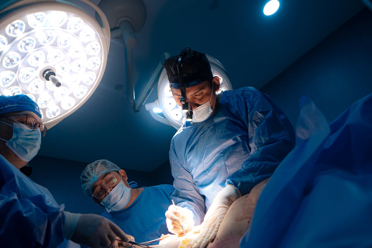 Team of surgeons focused on an operation in a well-lit operating room.